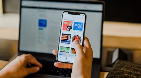 person using smartphone and laptop at the same time